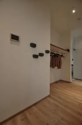 a room with a white wall with shoes on a wall at Cadix 35 in Antwerp