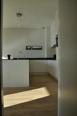 a white kitchen with a sink and a counter at Cadix 35 in Antwerp
