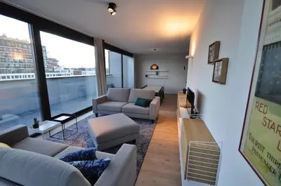 a living room with couches and a large window at Cadix 35 in Antwerp