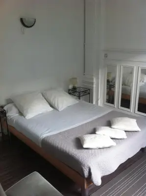 a bed with white pillows on it in a room at Résidence18 in Brussels