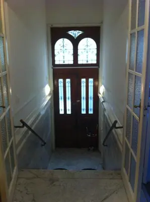 a hallway with a wooden door and two windows at Résidence18 in Brussels
