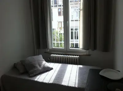 a bedroom with a bed in front of a window at Résidence18 in Brussels