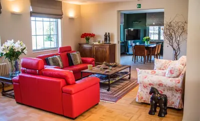 a living room with red chairs and a table at Aquarand in Hofstade