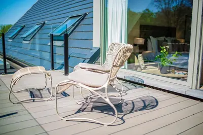 two rocking chairs sitting on a porch next to a window at Aquarand in Hofstade