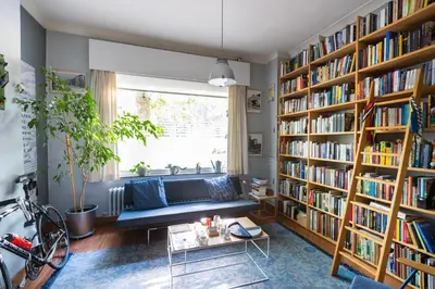 a living room filled with book shelves filled with books at Fred&Breakfast in Ghent