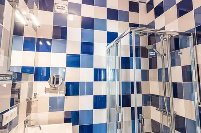 a bathroom with a shower and blue and white tiles at Fred&Breakfast in Ghent