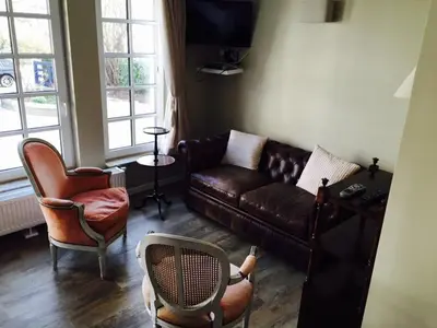 a living room with a brown leather couch and chairs at Bed and Breakfast Ros & Marc in Wezembeek-Oppem