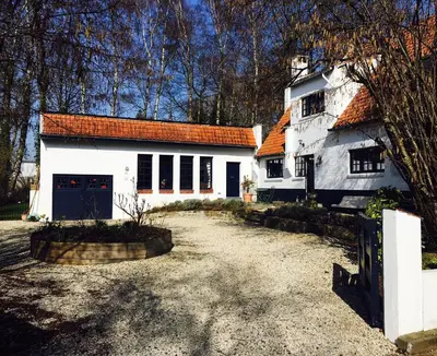 a white house with an orange roof and a driveway at Bed and Breakfast Ros & Marc in Wezembeek-Oppem