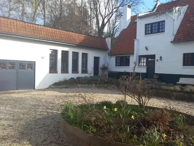 a white house with a red roof and a yard at Bed and Breakfast Ros & Marc in Wezembeek-Oppem