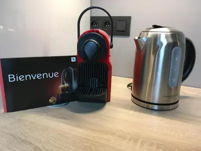 a red blender and a tea kettle on a table at All In One in Brussels