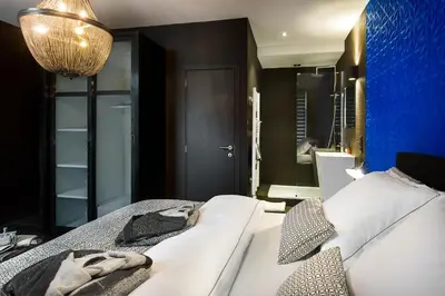 a bedroom with a bed and a blue wall at All In One in Brussels