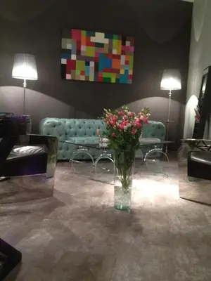 a vase of flowers in a living room with a couch at All In One in Brussels