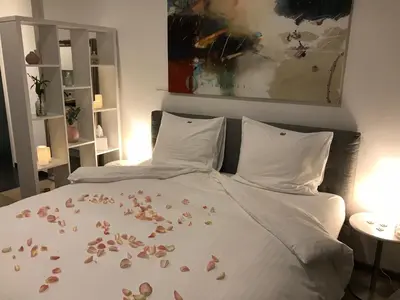 a bed with flower petals on the sheets at Antwerp Business Suites in Antwerp
