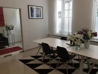 a dining room table with chairs and a vase of flowers at Antwerp Business Suites in Antwerp