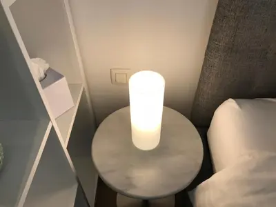 a table with a light on it next to a bed at Antwerp Business Suites in Antwerp