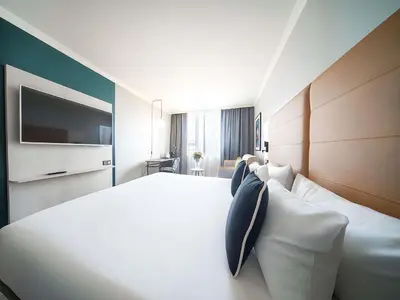 a hotel room with a large white bed with pillows at Maek Hotel Antwerp Central - Handwritten Collection by Accor in Antwerp