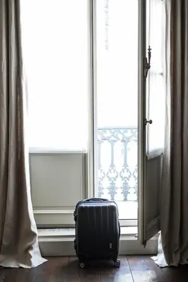 a suitcase sitting on the floor in front of a window at B&B Dusk till dawn in Mechelen