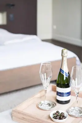 a bottle of champagne and two wine glasses on a table at B&B Dusk till dawn in Mechelen