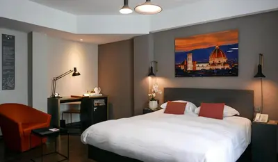 a hotel room with a large bed and a desk at Atlas Hotel Brussels in Brussels