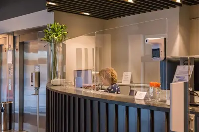 a woman sitting at a counter in a lobby at Atlas Hotel Brussels in Brussels