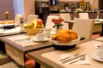 a table topped with a basket of bread and fruit at Atlas Hotel Brussels in Brussels