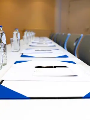 a long table with white papers and bottles of water at Atlas Hotel Brussels in Brussels