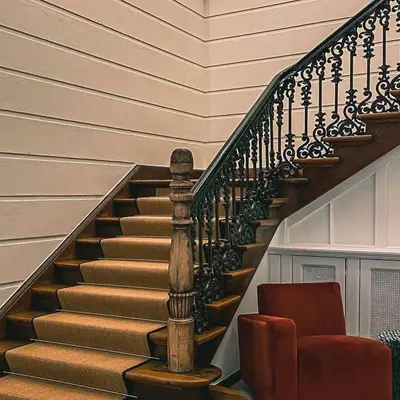 a staircase with a red chair next to a stair case at Hotel 'T Sandt in Antwerp