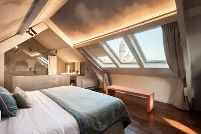 a bedroom with a large bed and a large window at Hotel 'T Sandt in Antwerp
