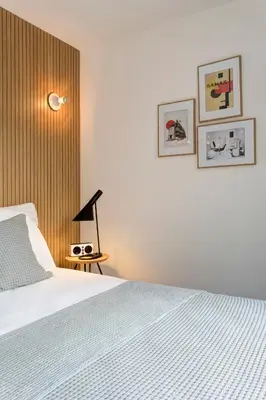 a bedroom with a bed and a wooden wall at Vintage Hotel Brussels in Brussels