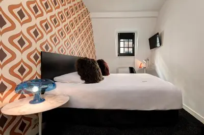a bedroom with a large bed with a teddy bear on it at Vintage Hotel Brussels in Brussels
