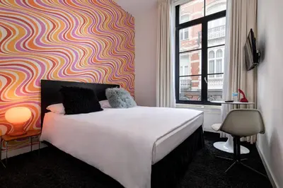 a bedroom with a bed and a colorful wall at Vintage Hotel Brussels in Brussels