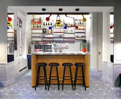 a kitchen with a bar with three stools at Vintage Hotel Brussels in Brussels