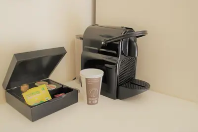 a coffeemaker and a coffee maker and a cup at Hostellerie De Biek in Moorsel