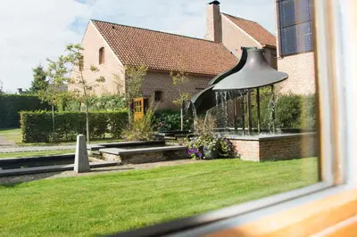 a window view of a house with a fountain at Hostellerie De Biek in Moorsel