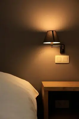 a lamp on a wall next to a bed at Boardhousing in Leuven