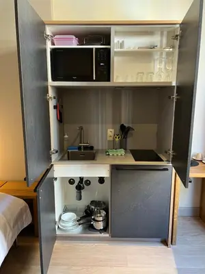 a small kitchen with a sink and a microwave at Boardhousing in Leuven