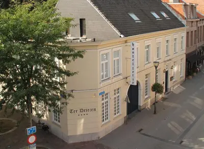 a white building with a sign on it on a street at Hotel Ter Driezen in Turnhout