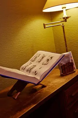 a book sitting on top of a desk with a lamp at Hotel Ter Driezen in Turnhout