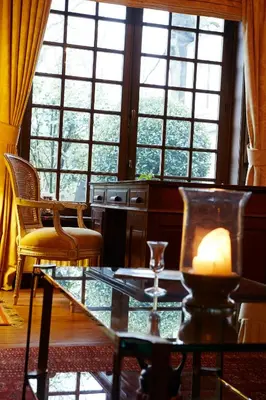 a living room with a table and chairs and windows at Hotel Ter Driezen in Turnhout