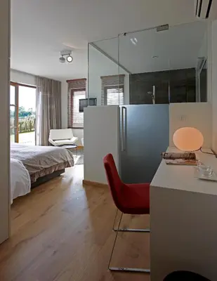 a bedroom with a bed and a red chair at B&B Baron’s House Neerijse-Leuven in Neerijse