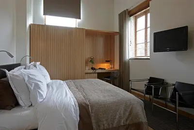 a bedroom with a bed with a television on the wall at B&B Baron’s House Neerijse-Leuven in Neerijse