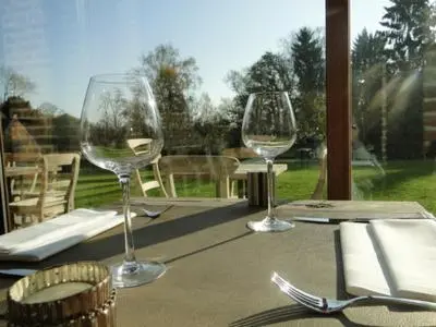 three wine glasses sitting on top of a table at B&B Baron’s House Neerijse-Leuven in Neerijse