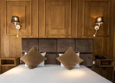a bedroom with a bed with two pillows and two lights at Hotel Esperance in Brussels