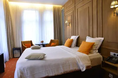 a hotel room with a large white bed with orange pillows at Hotel Esperance in Brussels