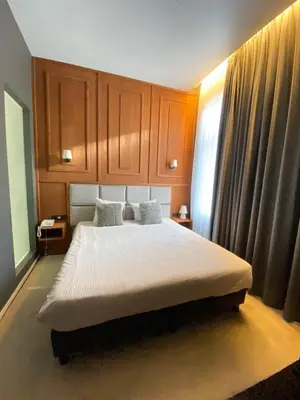 a bedroom with a large bed with wooden cabinets at Hotel Esperance in Brussels