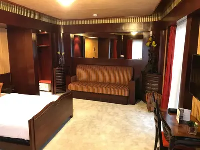 a bedroom with a bed and a couch and a table at Hotel Esperance in Brussels