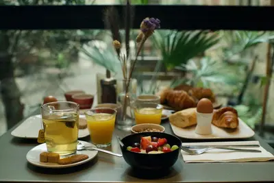 a table topped with plates of food and glasses of orange juice at Hotel Matelote in Antwerp