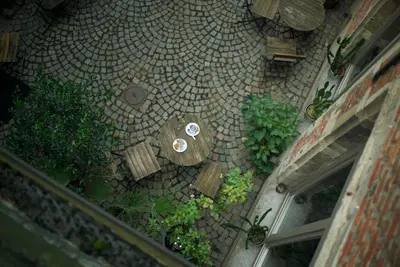 an overhead view of a patio with tables and plants at Hotel Matelote in Antwerp