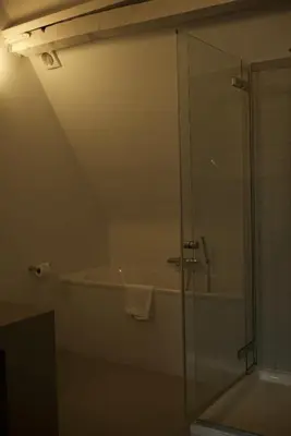 a bathroom with a shower and a bath tub at Hotel Matelote in Antwerp