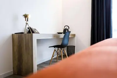 a chair sitting next to a fireplace in a bedroom at B-INN Lier in Lier